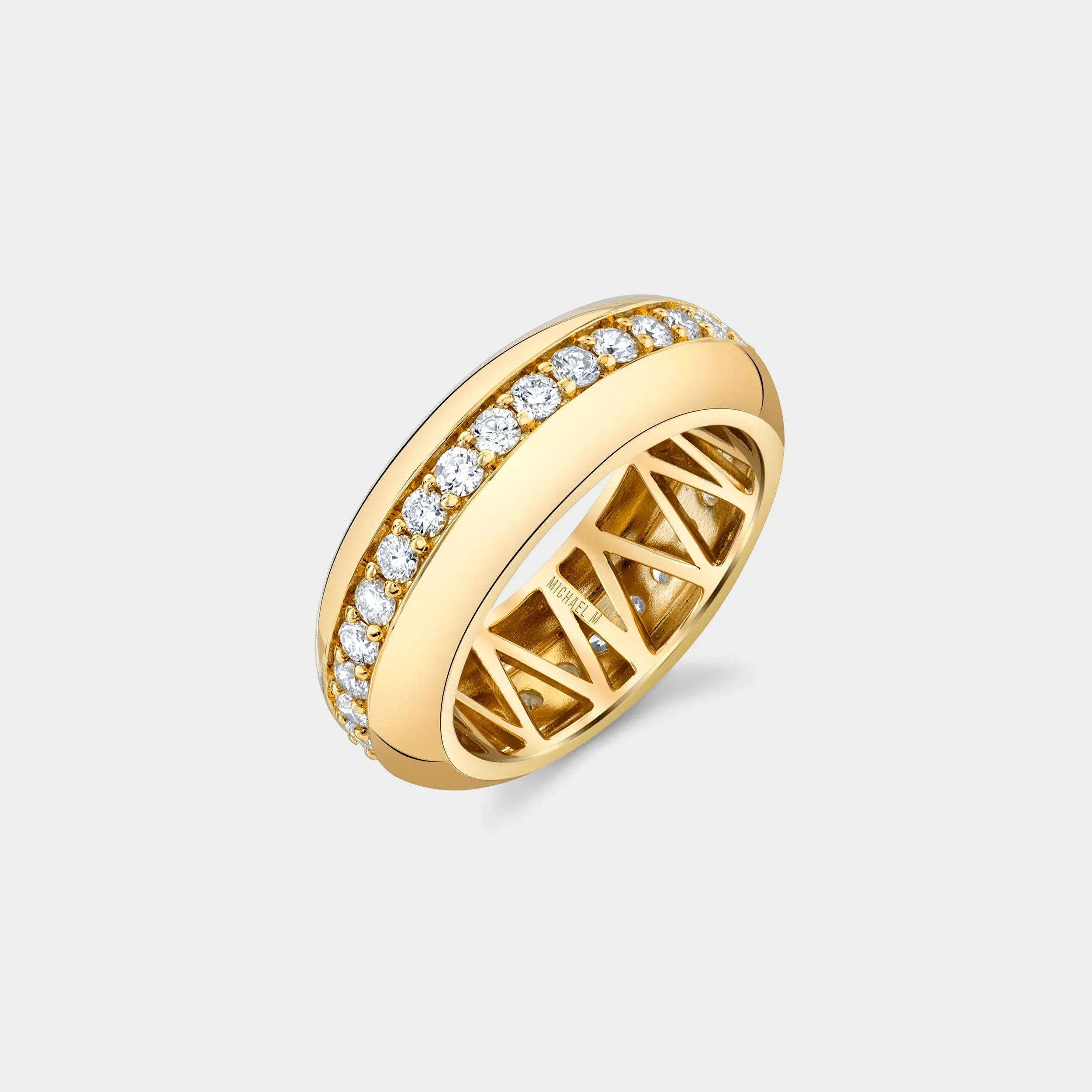 Yellow gold fashion ring with diamond center row on grey background, side angle view