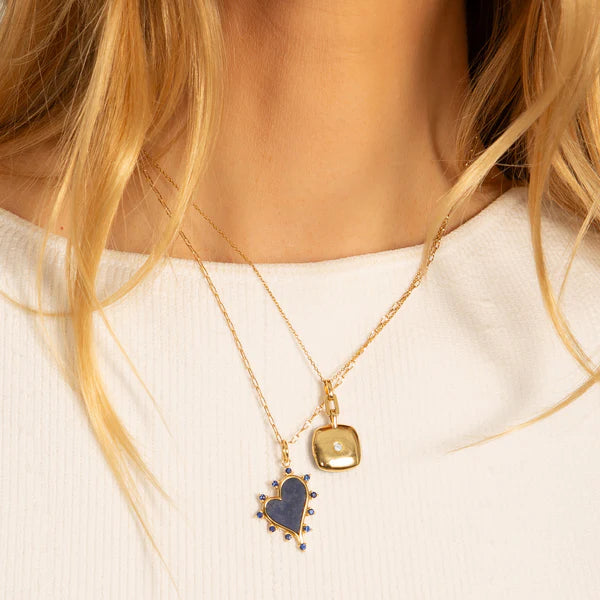 Woman wearing yellow gold photo locket necklace with two photos