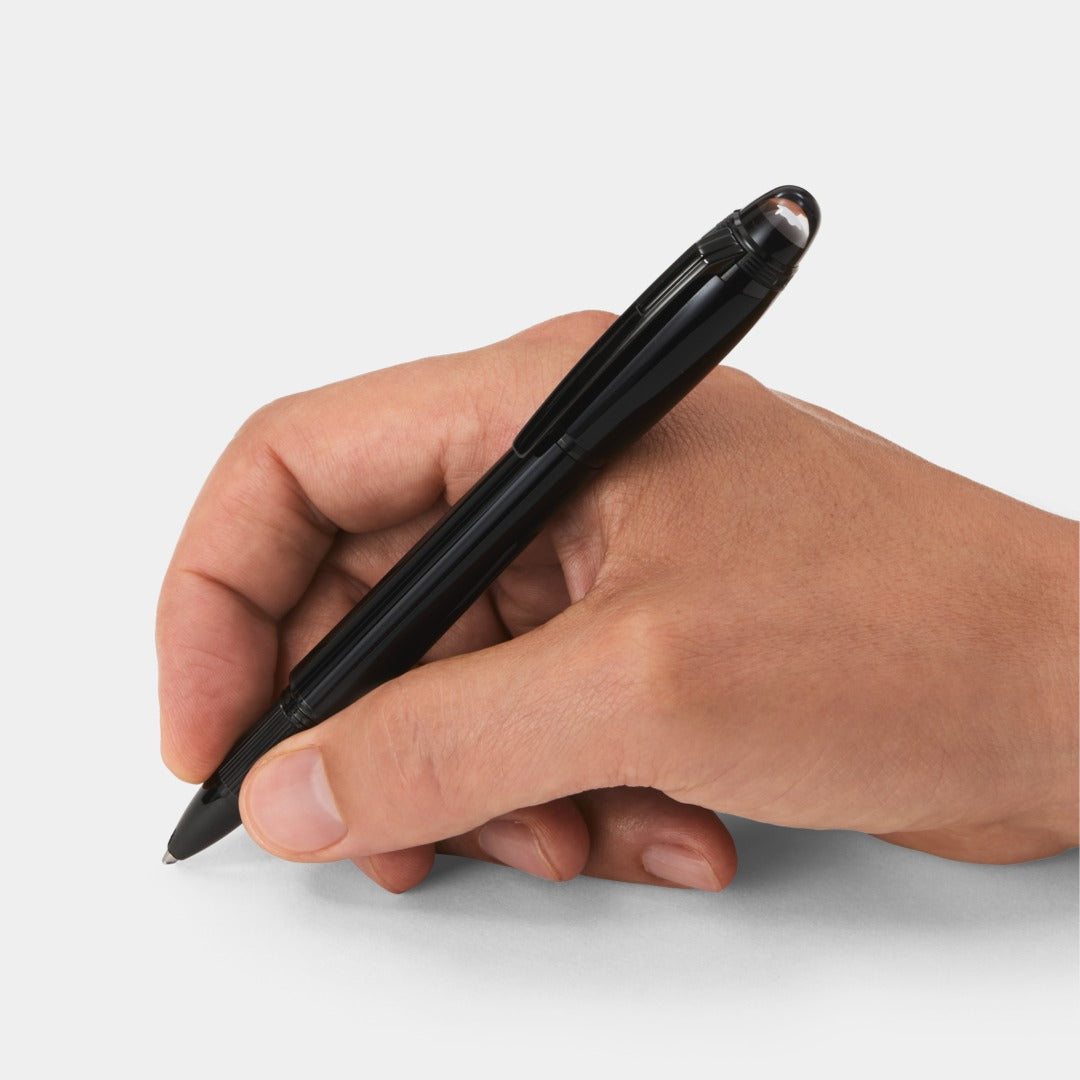 Hand holding a black pen on a white background