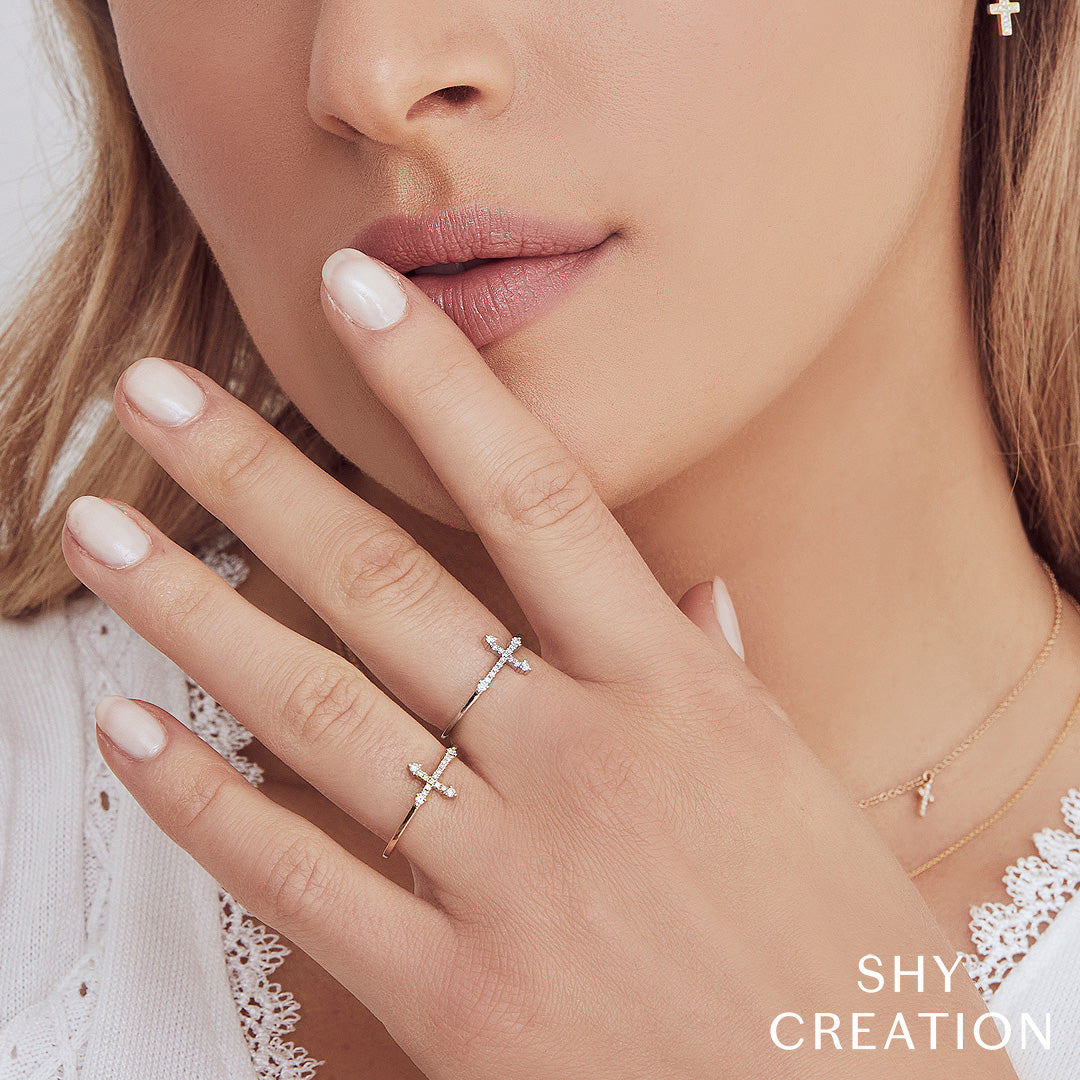 Woman wearing yellow gold east-west diamond cross ring