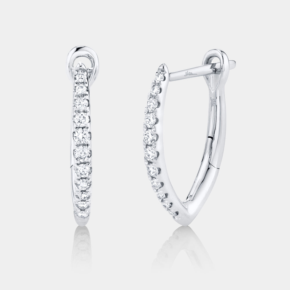 Woman wearing white gold diamond hoop earrings, upright front view