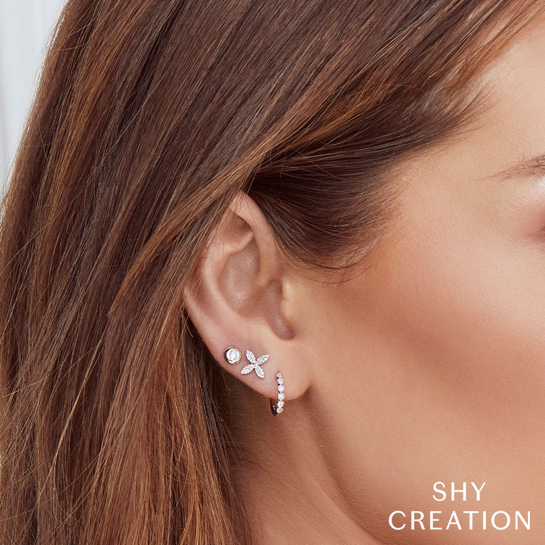Woman wearing white gold diamond huggie earrings