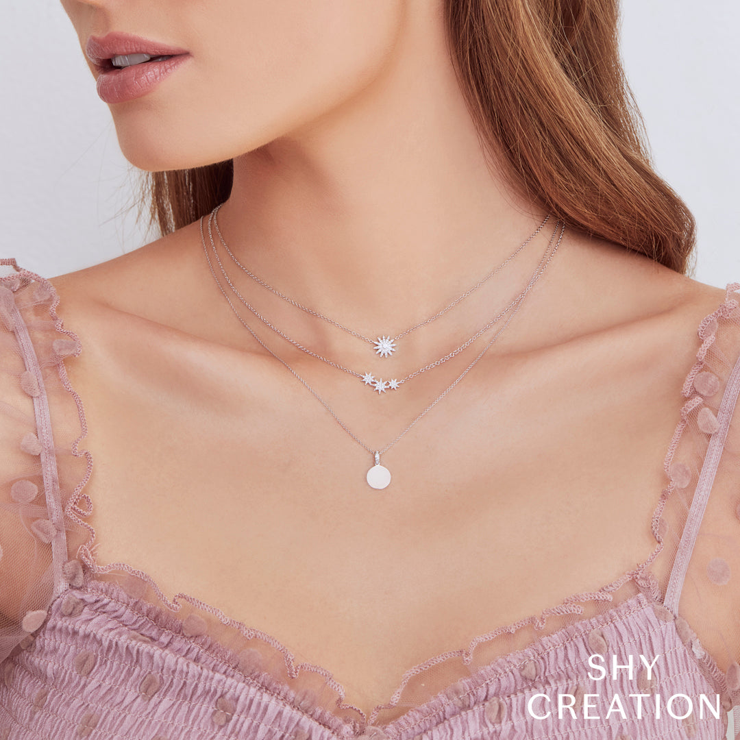 Women wearing white gold starburst diamond pendant necklace