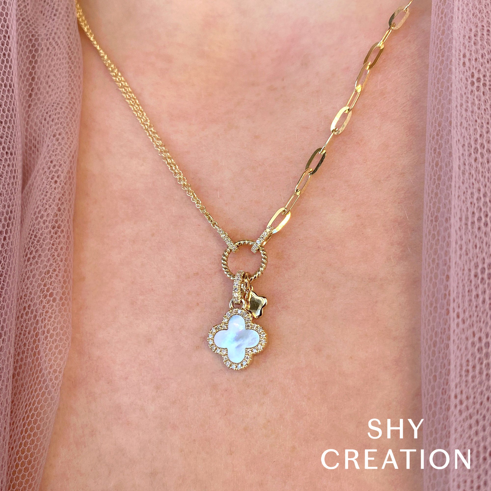 Woman wearing yellow gold diamond clover necklace with white mother of pearl inlay