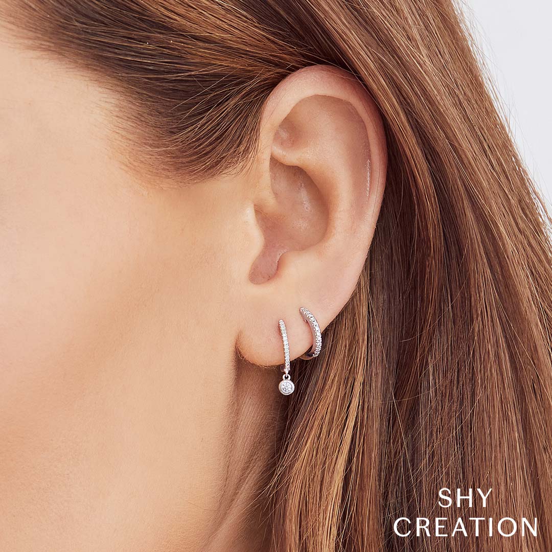 Woman wearing white gold diamond huggie earrings