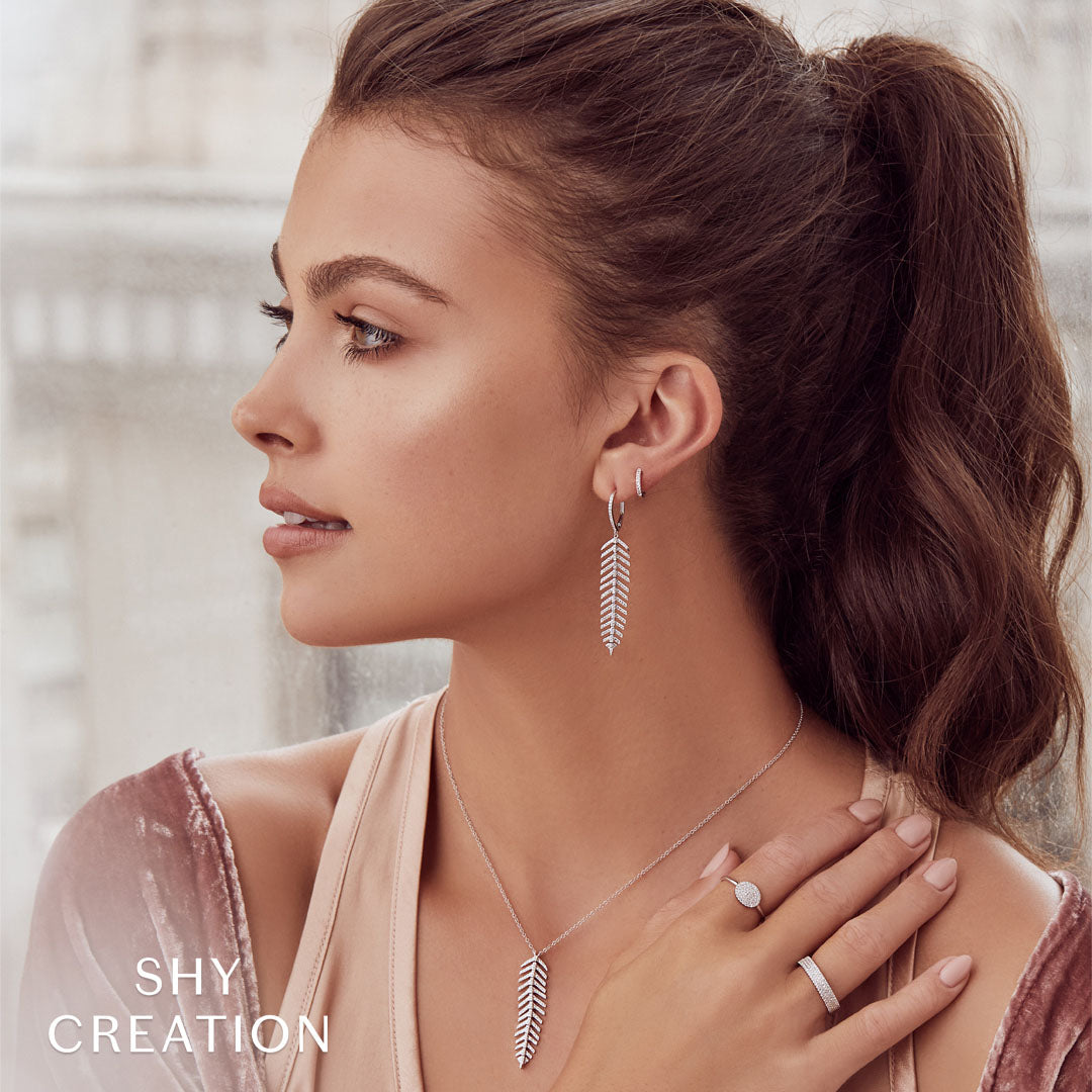 Woman wearing white gold diamond huggie earrings