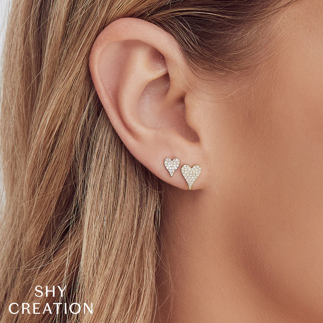 Woman wearing white gold pave heart diamond stud earrings