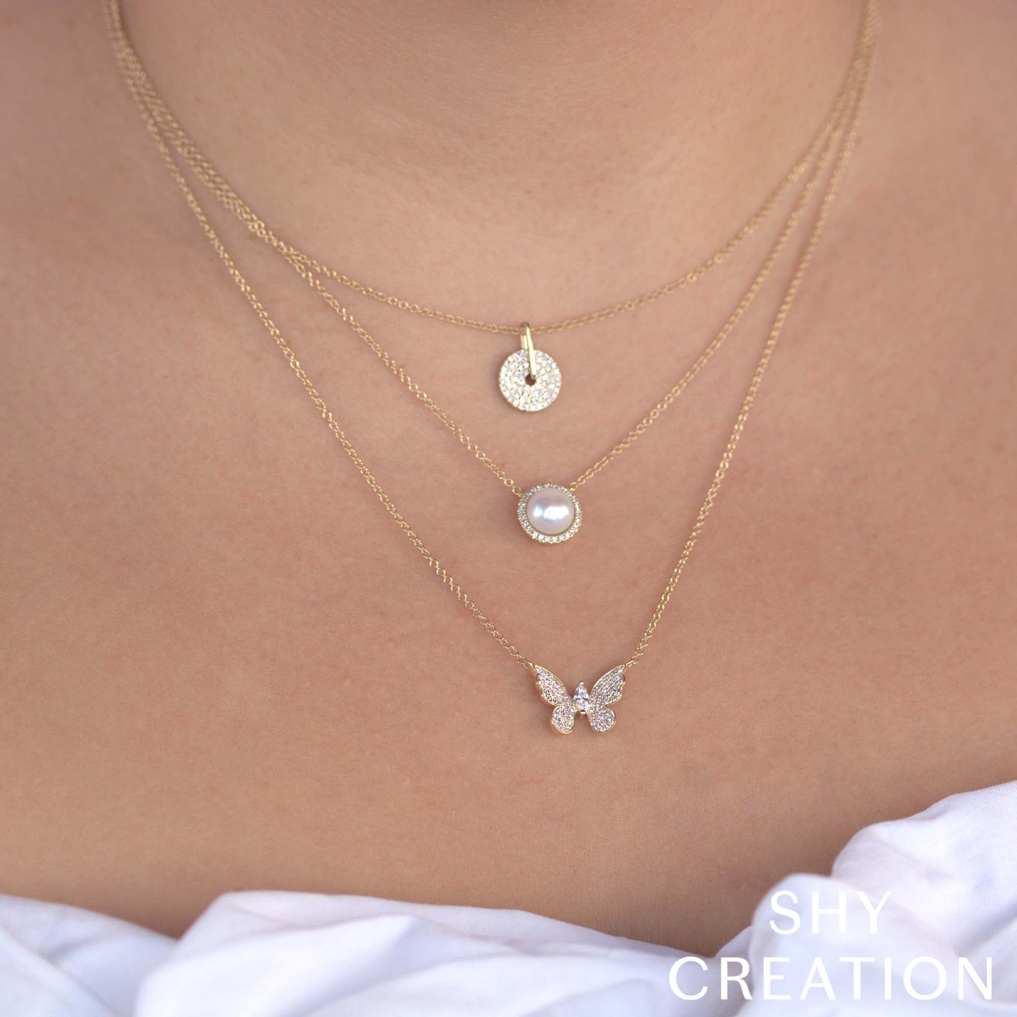 Woman wearing pearl necklace with gold chain and diamond accents