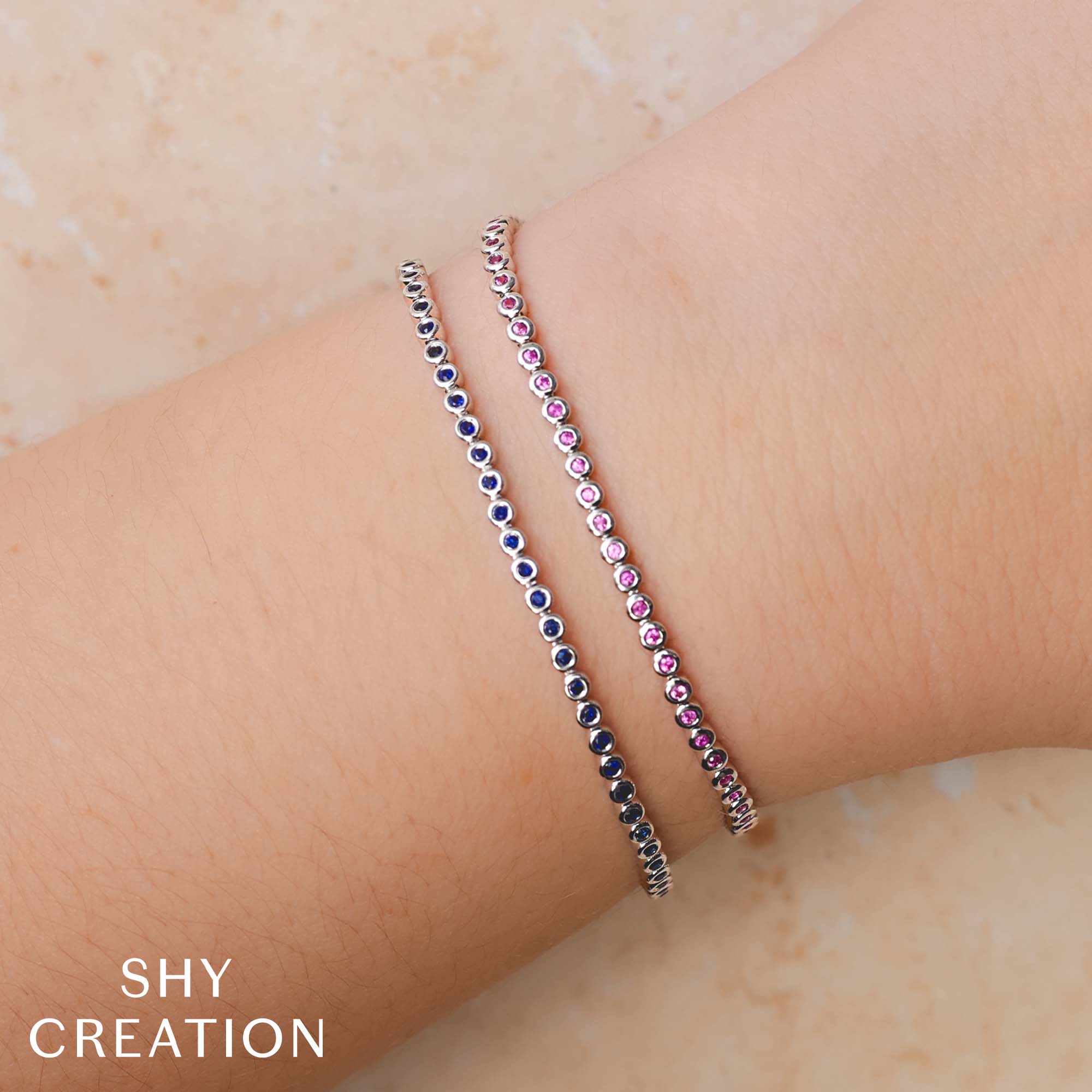Woman wearing white gold sapphire tennis bracelet, wrist close-up