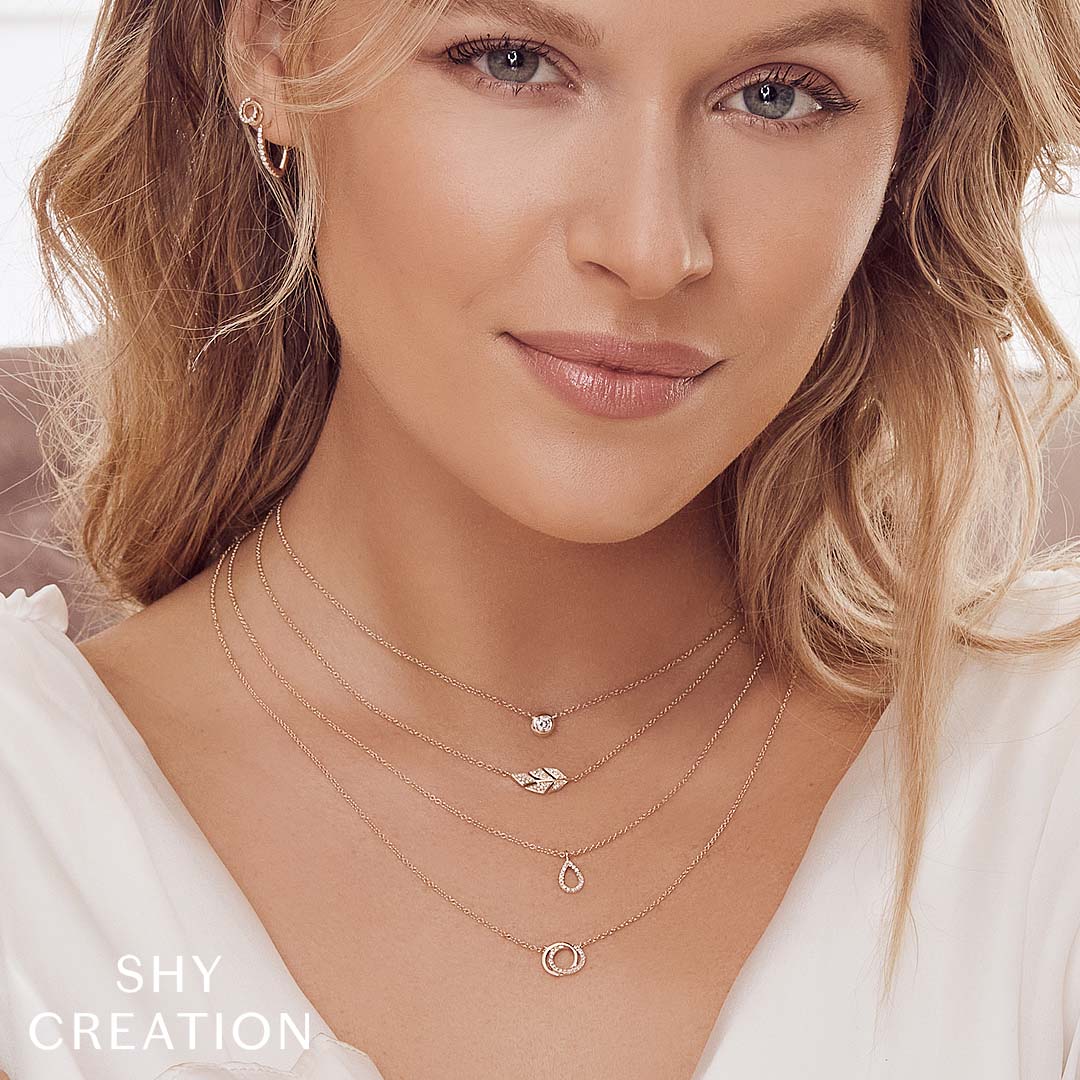 Woman wearing yellow gold bezel-set diamond pendant necklace