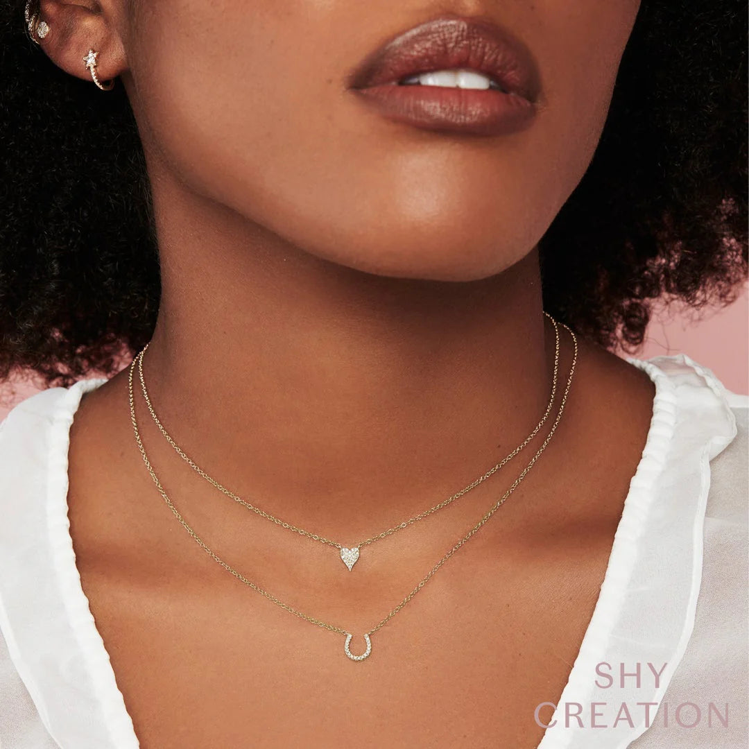 Woman wearing yellow gold diamond horseshoe necklace, front  view