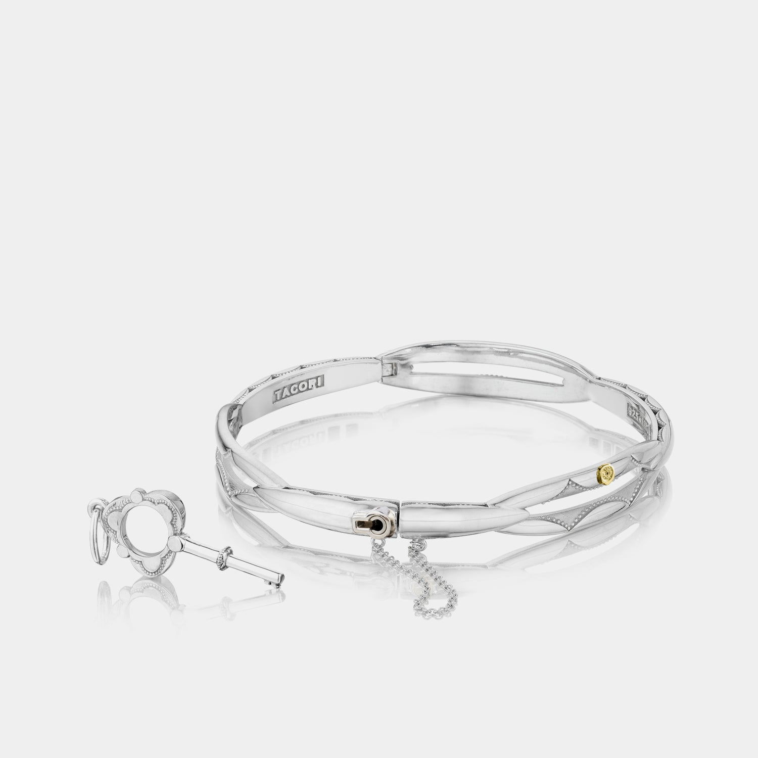 Sterling Silver and 18K Gold Promise Bangle Bracelet with Key on grey background.