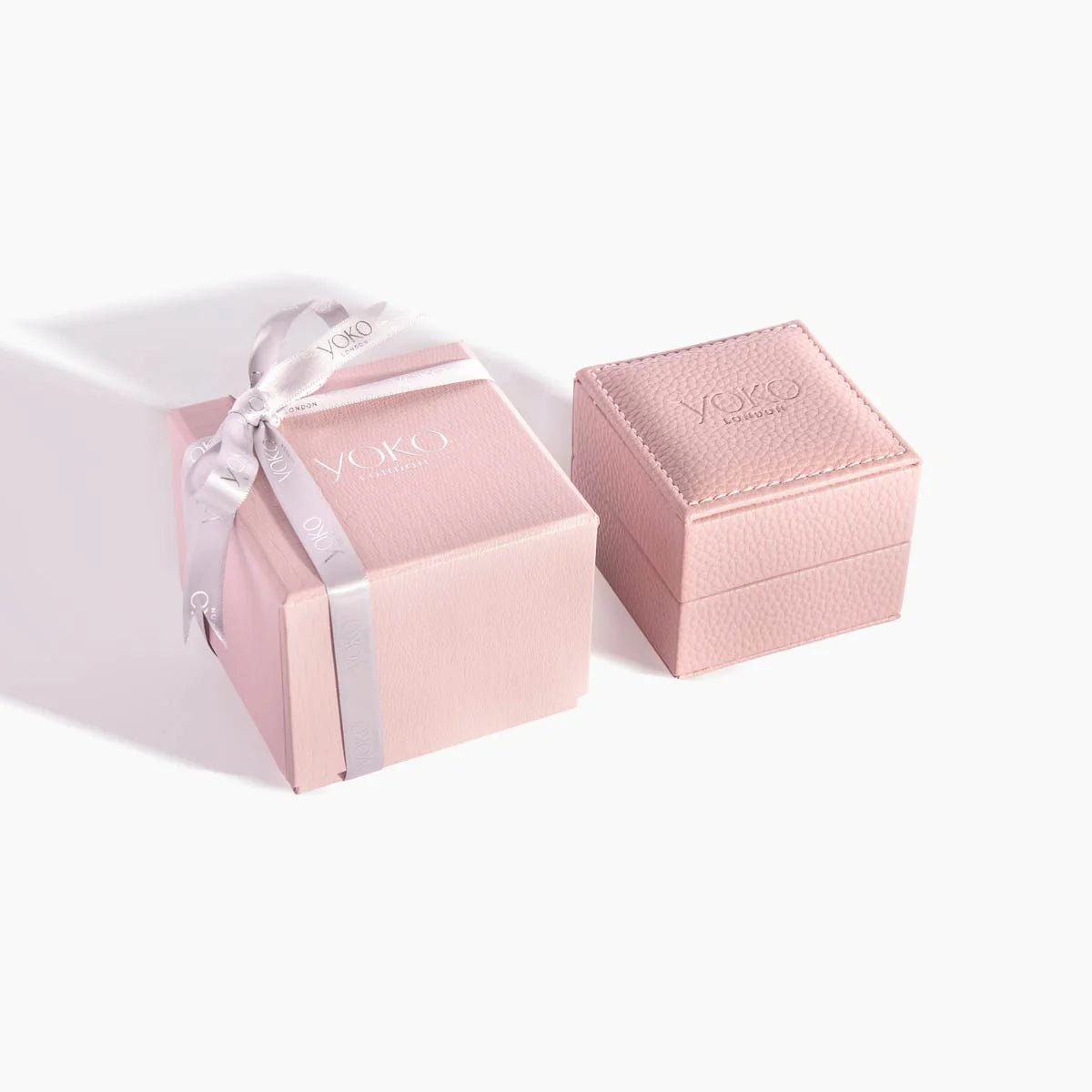 Pink jewelry box with a ribbon and 'Yoko' branding on a white background