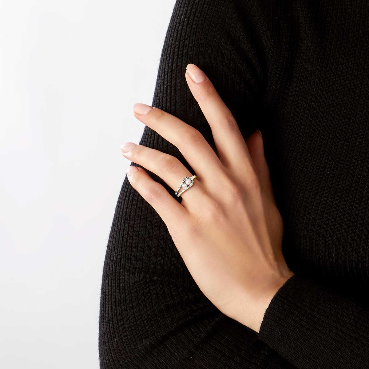 Woman wearing yellow gold fashion ring with two white pearls and diamond accents