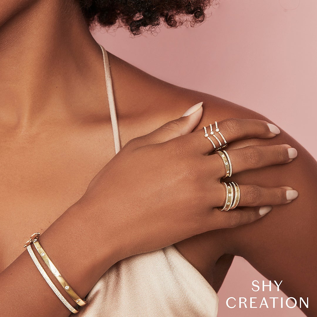 Woman wearing yellow gold bezel set diamond stacking ring