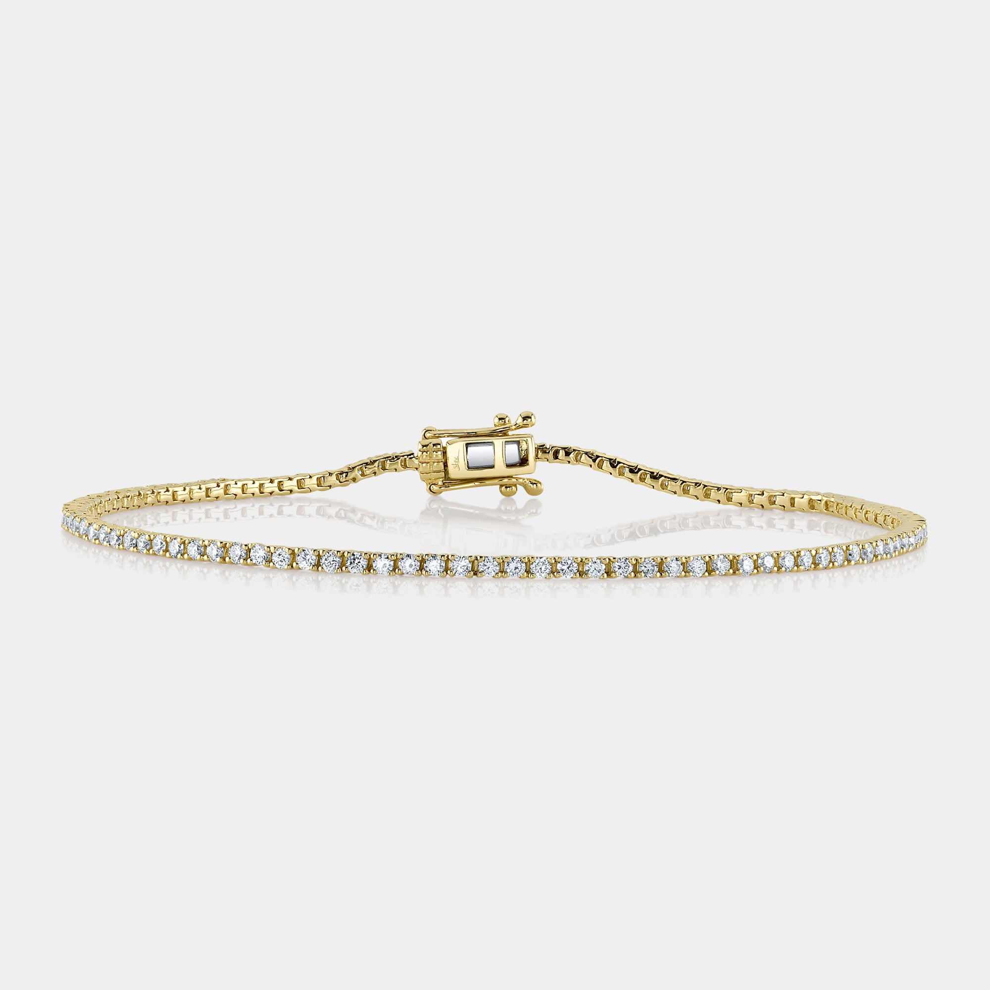 Yellow gold diamond tennis bracelet, front angle view on grey background