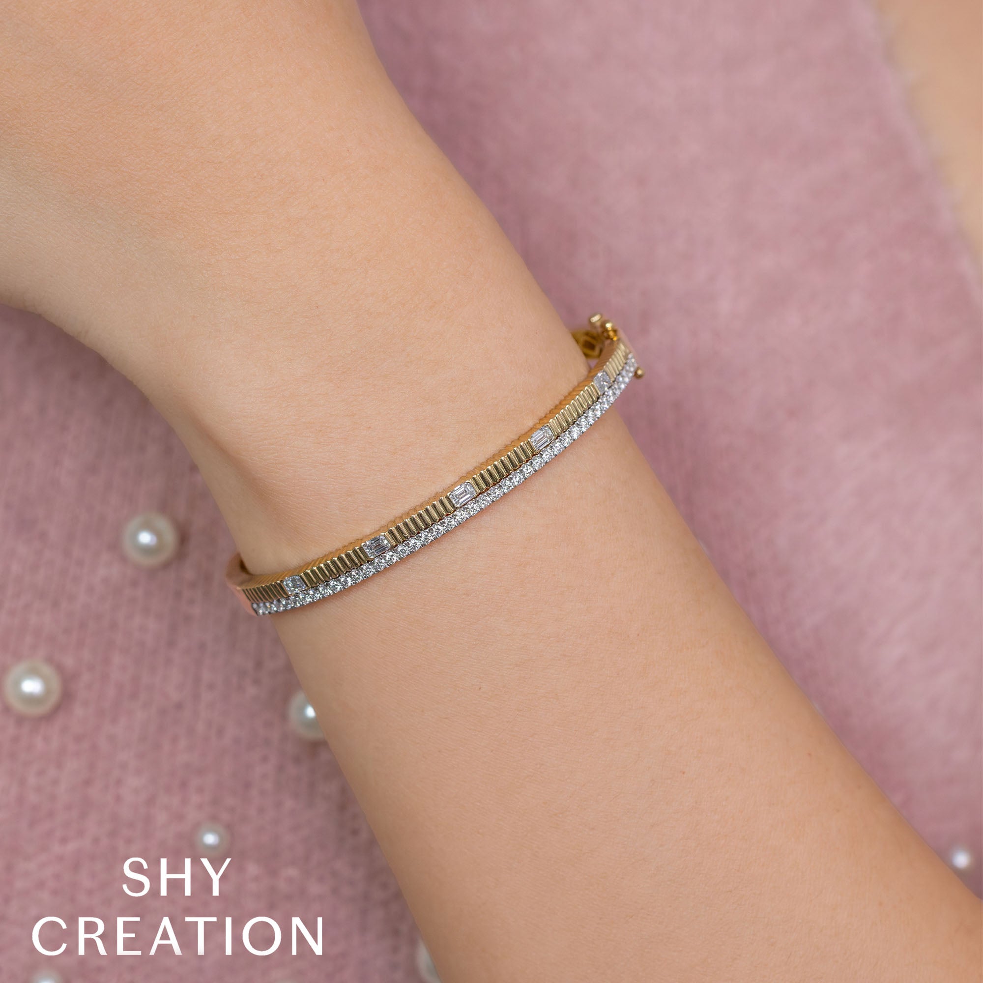 Woman wearing yellow gold diamond ribbed bangle bracelet, wrist closeup